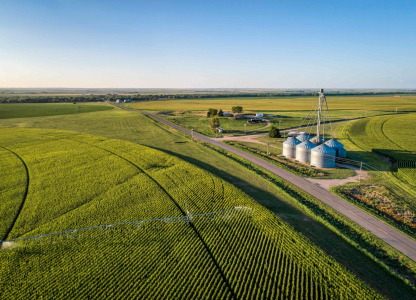 aerial view of corn field with sprinkler, silo, and farm buildings in eastern Colorado