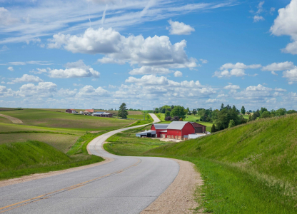 Farm with a red barn on a curving road in the Iowa countryside on a beautiful spring day