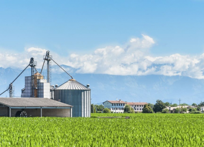 Agricultural landscape with old farm and silos and mountains in background